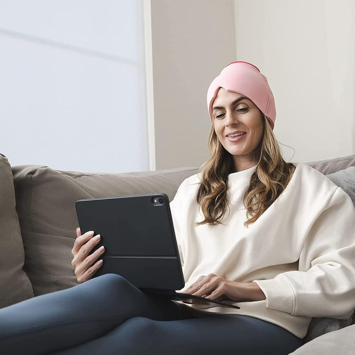 360° Massage Migraine Relief pink flexible gel cap with full coverage around head and eyes worn by woman relaxing on couch