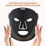 7 Color Rechargeable LED black silicone face mask with eye, nose, and mouth cutouts and gold curved lines, held by hands