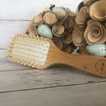 Eco-friendly bamboo paddle brush with natural wooden bristles for gentle detangling and scalp massage