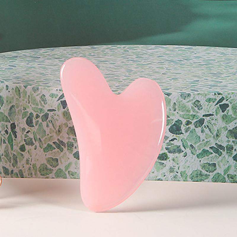 Heart-shaped rose quartz gua sha facial massage tool for lymphatic drainage and contouring