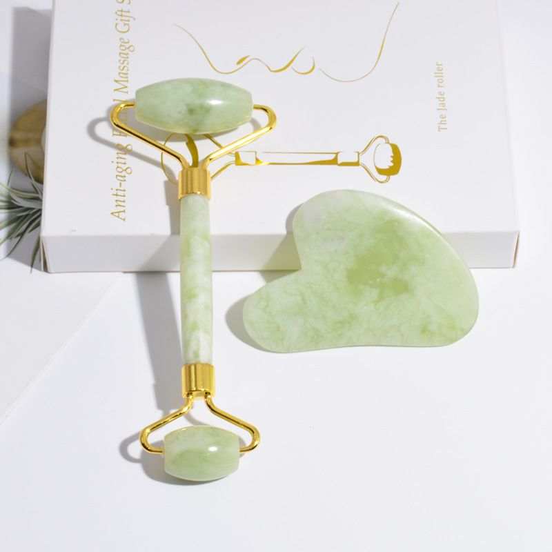Jade Roller and Gua Sha set in light green natural jade with smooth polished surfaces and gold metal accents