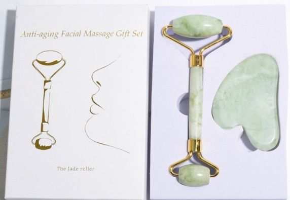 Jade Roller and Gua Sha set made of natural light green jade with gold metal accents, including a dual-ended roller and curved gua sha tool