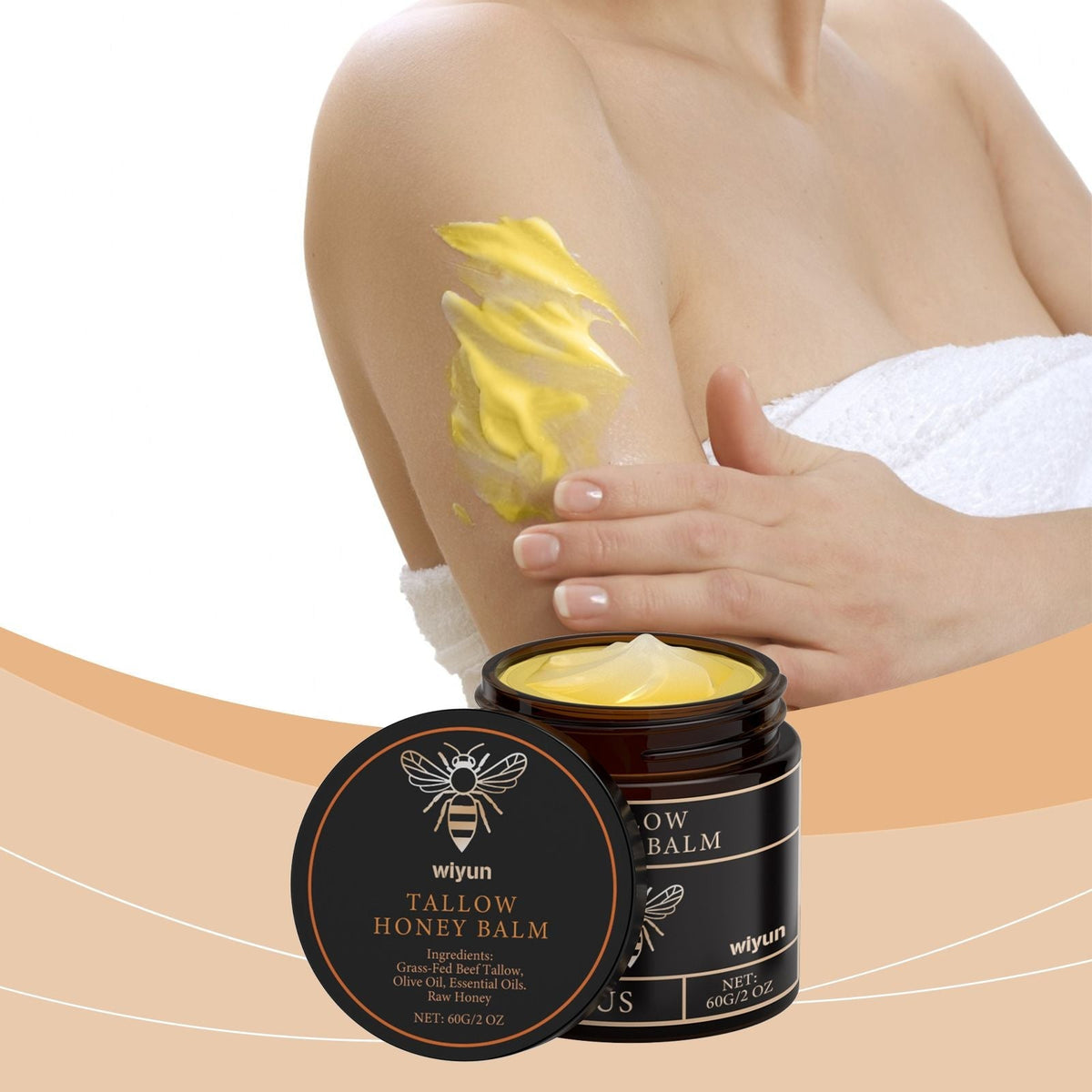 Revitalizing Beef Tallow honey balm in dark jar with creamy yellow moisturizer applied on woman's arm, soothing skincare product
